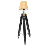 An adjustable tripod stand lamp with a black aluminum frame and a beige wooden base, featuring a modern design.